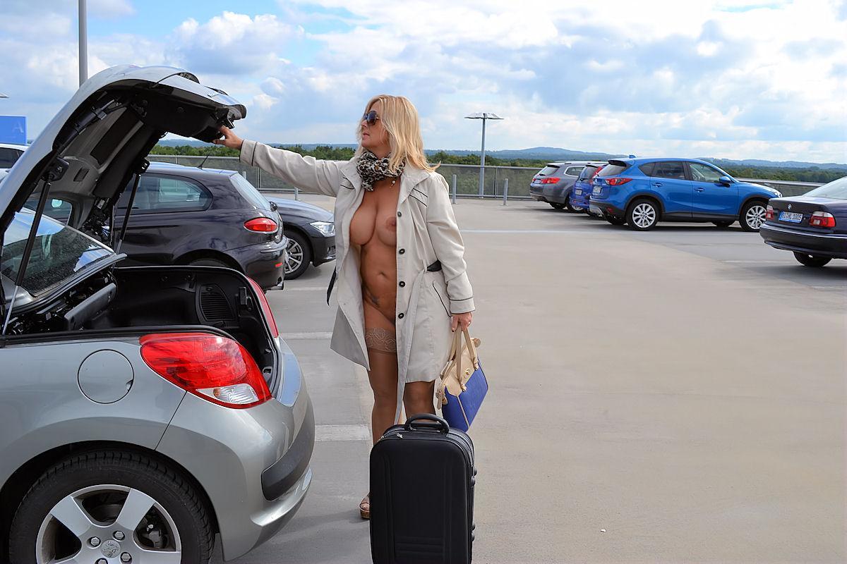 Mature blonde exposes herself in a trench coat at the airport  